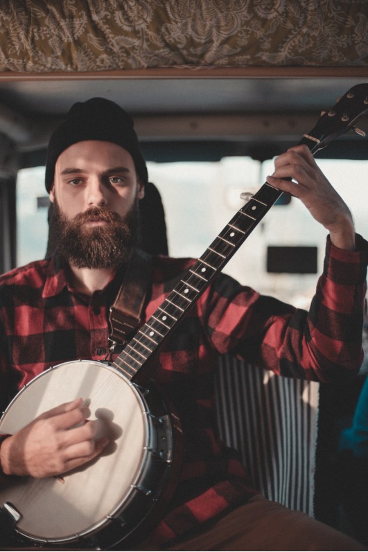 man in flannel shirt playing Banjo